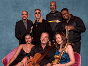 Portrait image of septet members against blue sky photo background 
