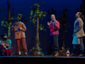 Actors rehearse live theater production against blue backdrop