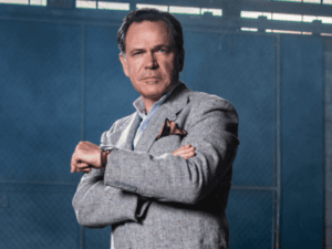 Kurt Elling stands with his watch out and his arms folded